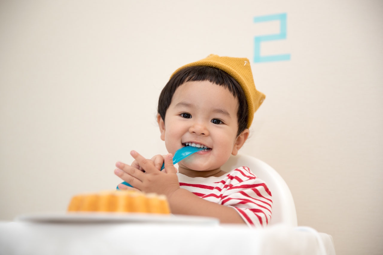 Smiling infant about to eat a cake