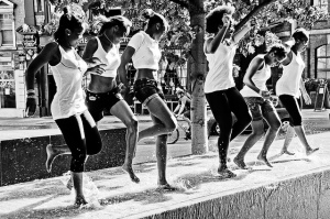 Black and white photo of women dancing in a street