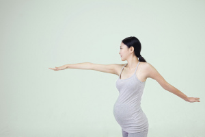 Pregnant woman stretching her arms horizontally
