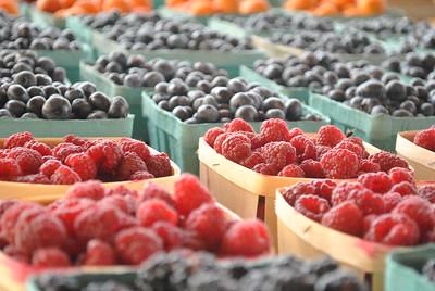 A variety of fresh berries are shown including raspberries and blueberries.