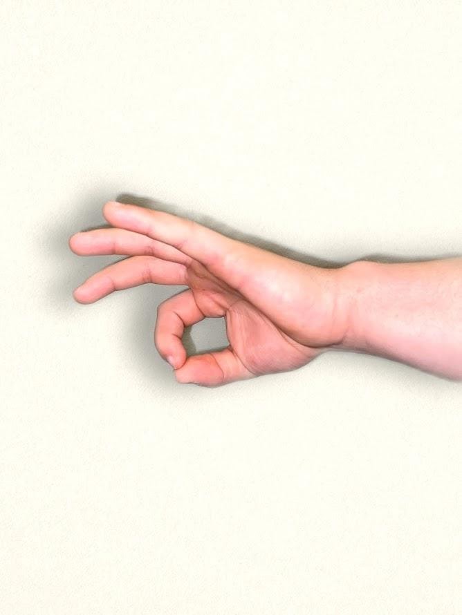Foto que muestra una mano con el pulgar y el dedo índice tocando