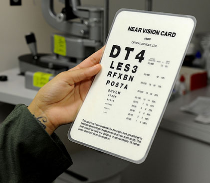 Foto de una persona que sostiene una tarjeta para evaluar la visión cercana
