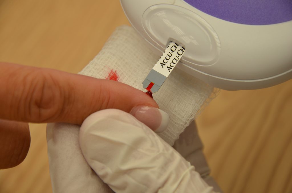 Foto que muestra la obtención de una gota de sangre en una tira médica