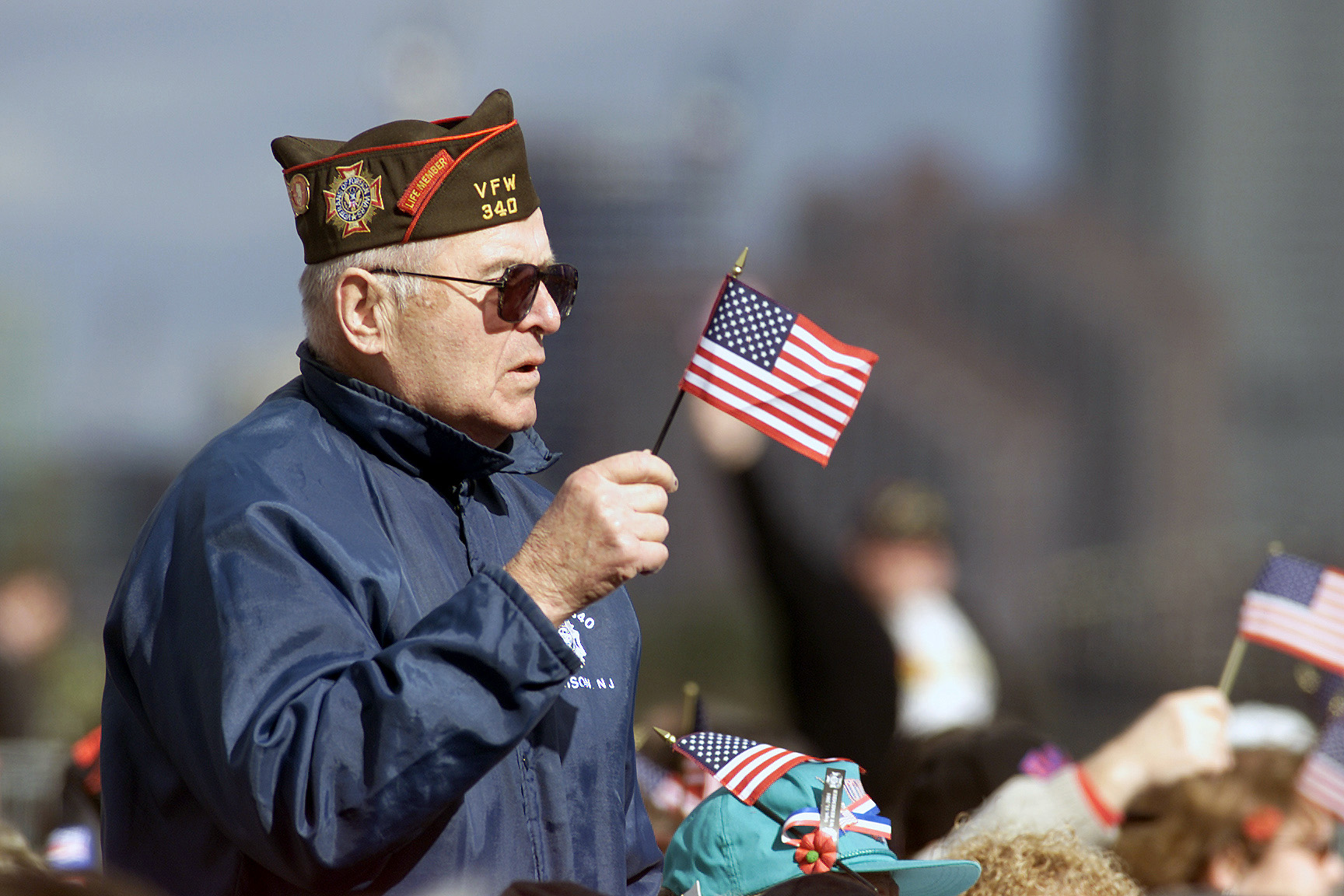 Photo showing an Armed Forces Veteran holding a small handheld American flag