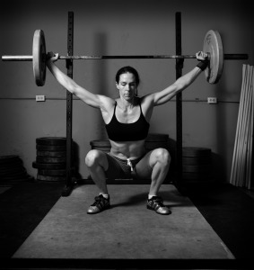 Photograph of female squatting under weight bar