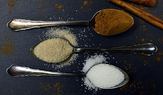 Teaspoons of cinnamon and sugar on a table