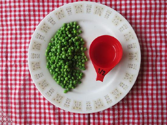 Photo of a plate of peas with a half cup measuring cup