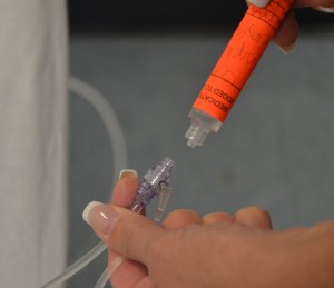 Attach medication syringe to the lowest port