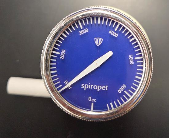A round blue gauge with a silver rim, marked with measurements and a white needle pointing slightly past the midpoint.
