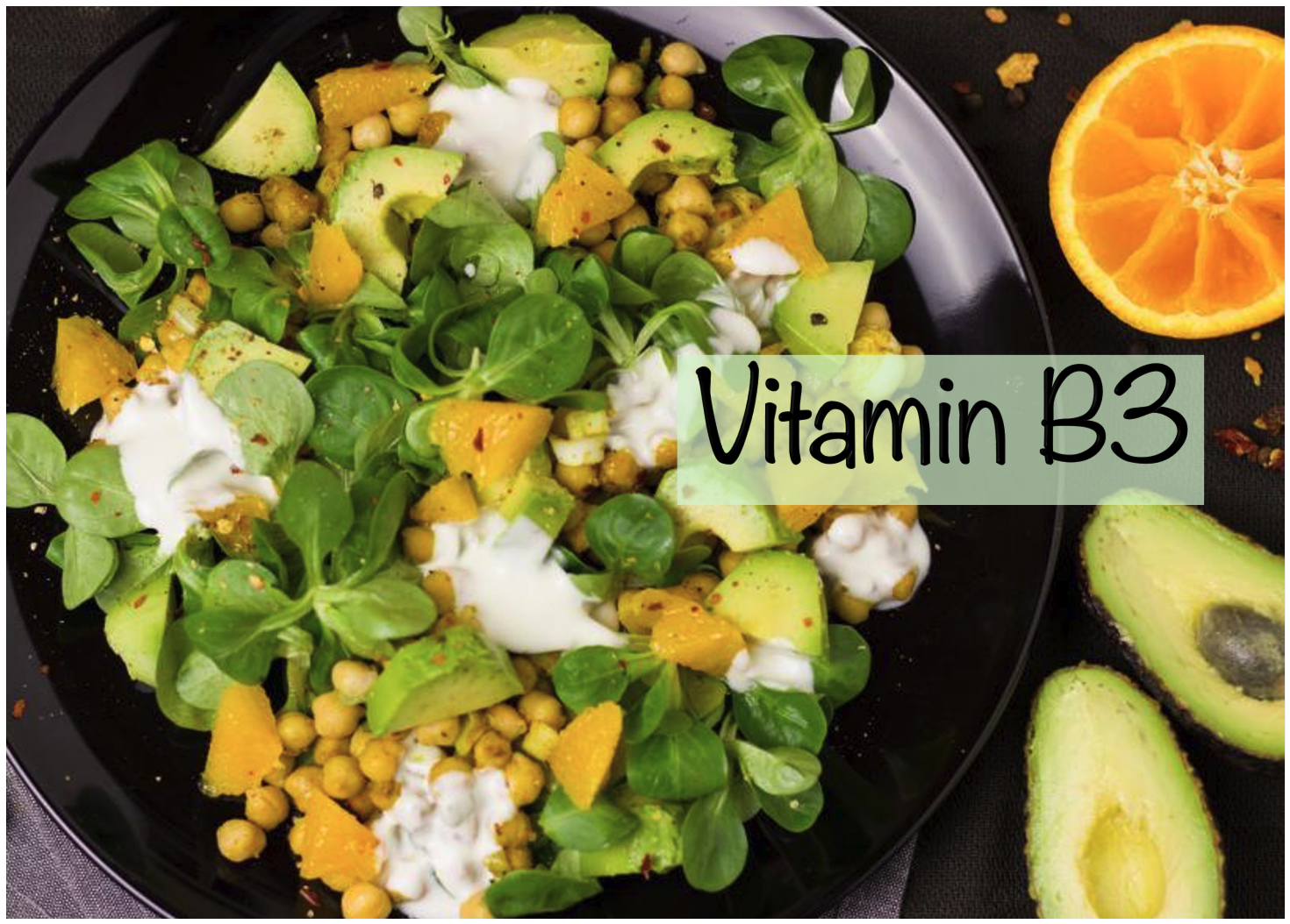 A vibrant salad with leafy greens, avocado, chickpeas, and orange segments, garnished with a creamy dressing.